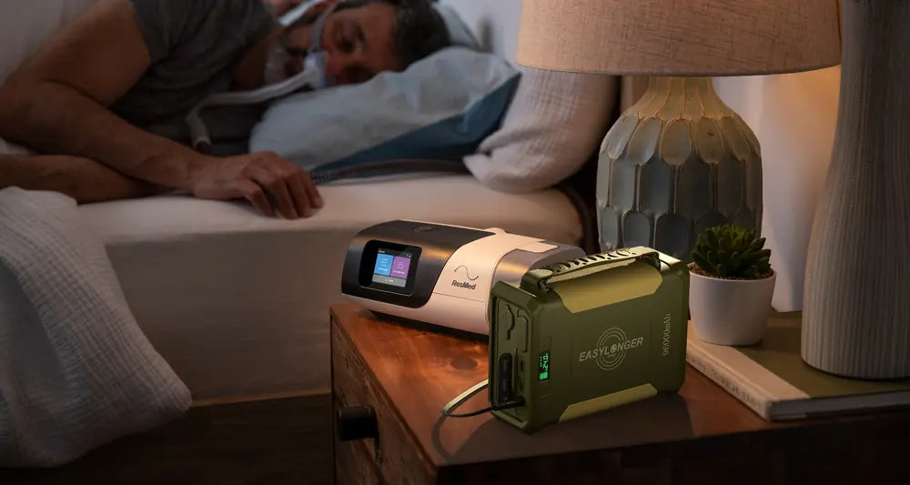 A man asleep while an ES960 runs his CPAP in a dark bedroom