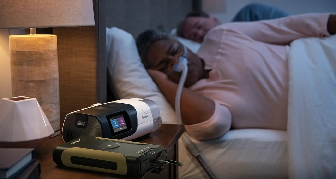 An ES720 on a lamp-lit nightstand, connected to a CPAP