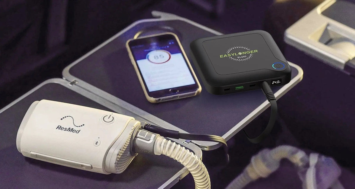 EASYLONGER EL240 and ResMed AirMini arranged on an airplane tray beside a phone