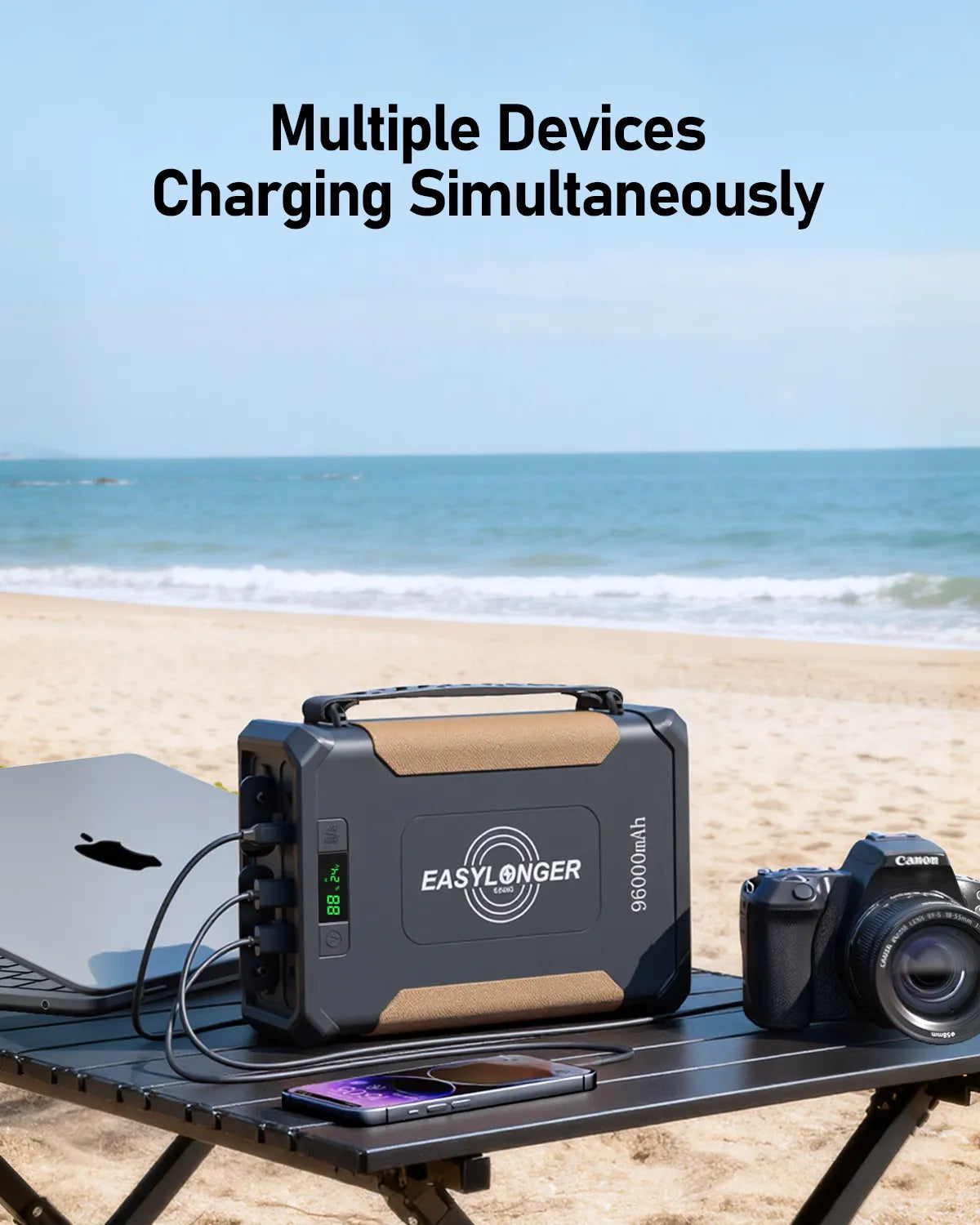 portable power station on beach table charging laptop, smartphone, camera, EASYLONGER logo visible